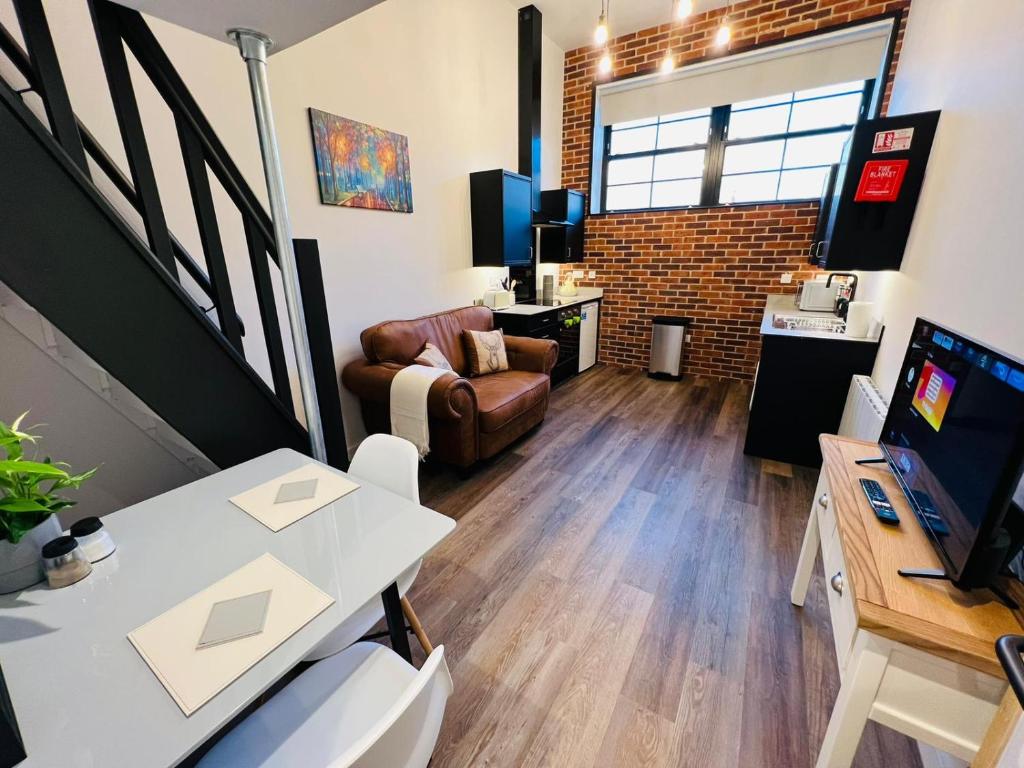 een woonkamer met een bank en een bureau met een computer bij Apartment 7 Sullivan House in Hereford
