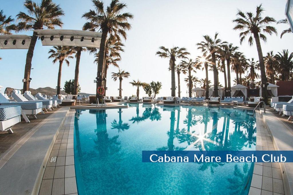 una piscina en un resort con palmeras en Cabanavillas Casablanca by PosarelliVillas, en Plaka