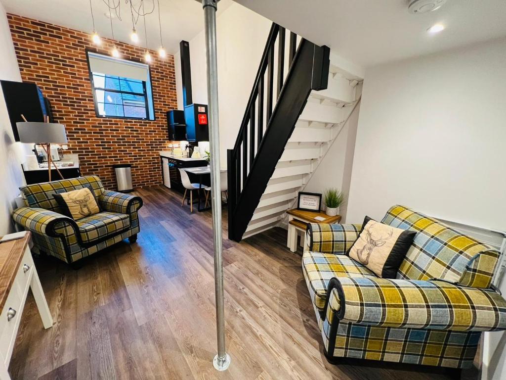 a living room with two couches and a staircase at Apartment 8 Sullivan House in Hereford