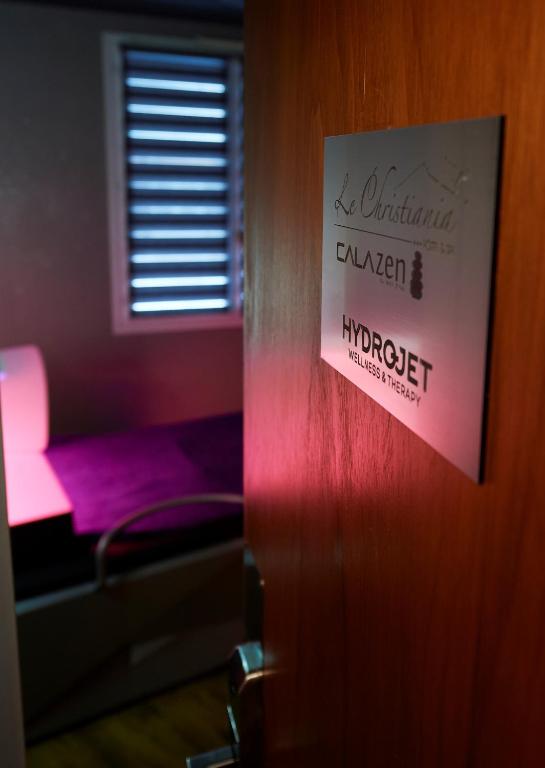 a sign on the door of a room with a bed at Logis Hôtel et Spa Le Christiania in La Salle-les-Alpes