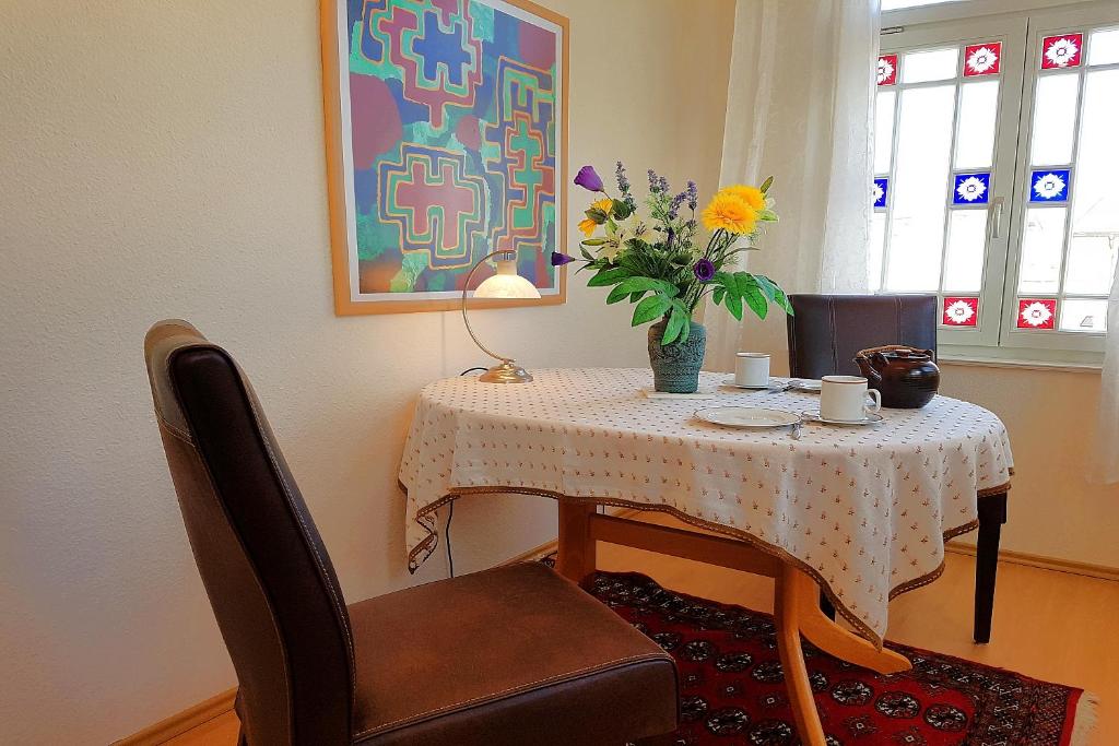 a dining room table with a vase of flowers on it at Bellevue-App-05 in Ahlbeck