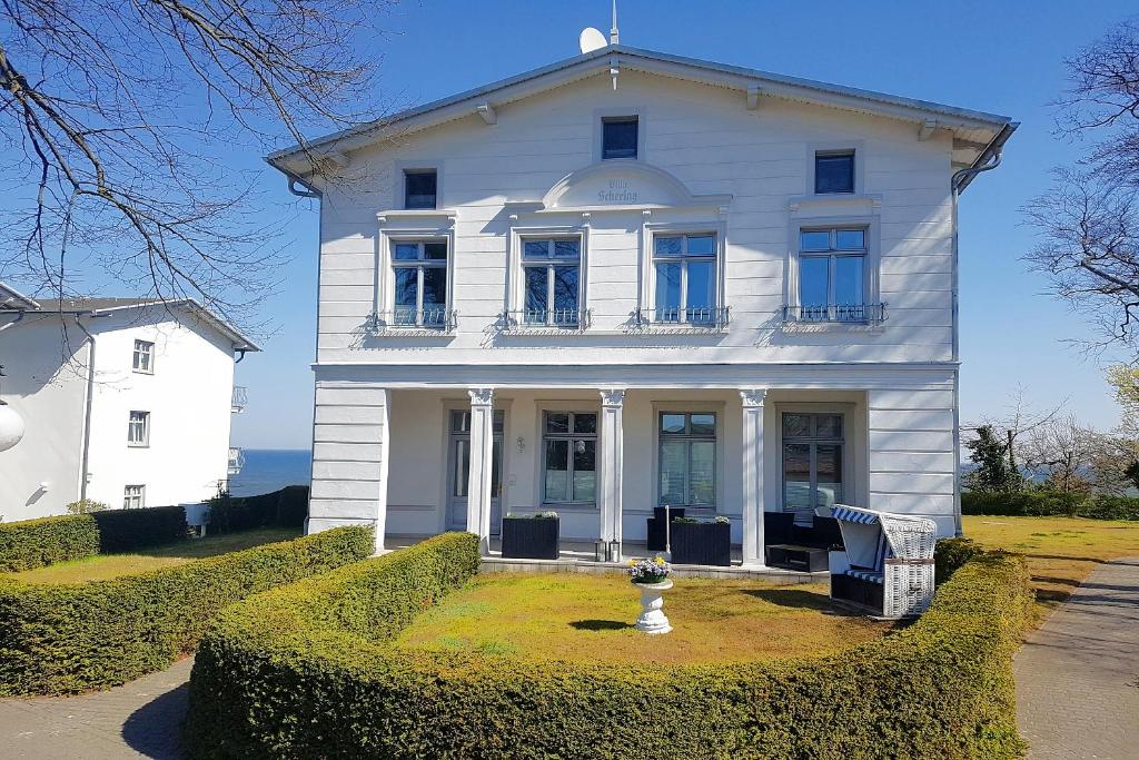 ein weißes Haus mit einer Vase davor in der Unterkunft Villa Schering App. EG links in Heringsdorf