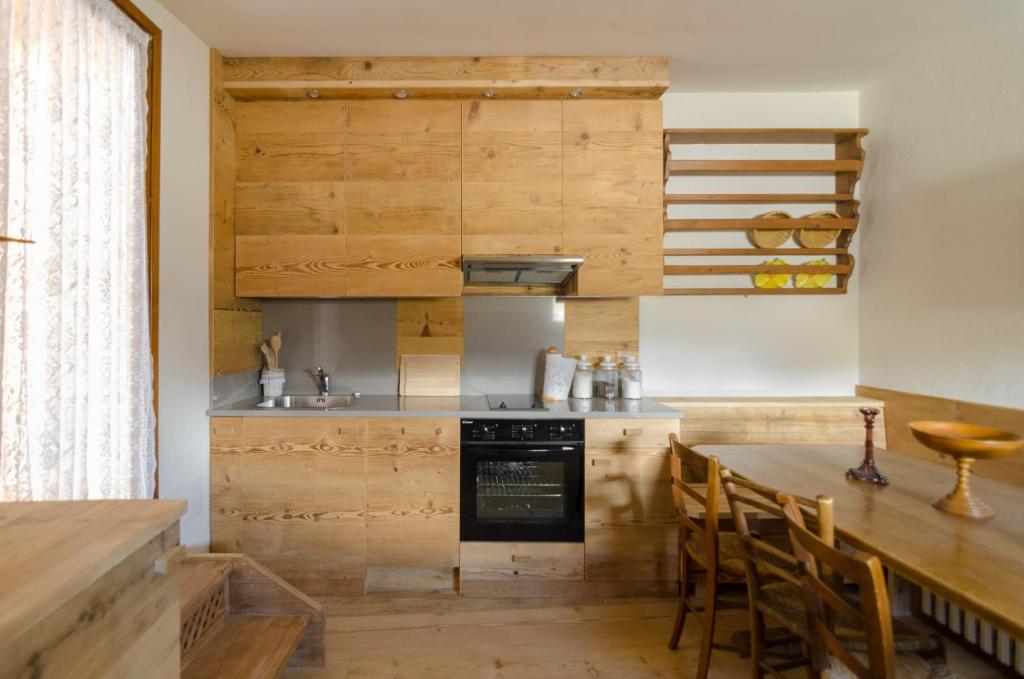 a kitchen with wooden cabinets and a table with chairs at Charming Studio in Chiave