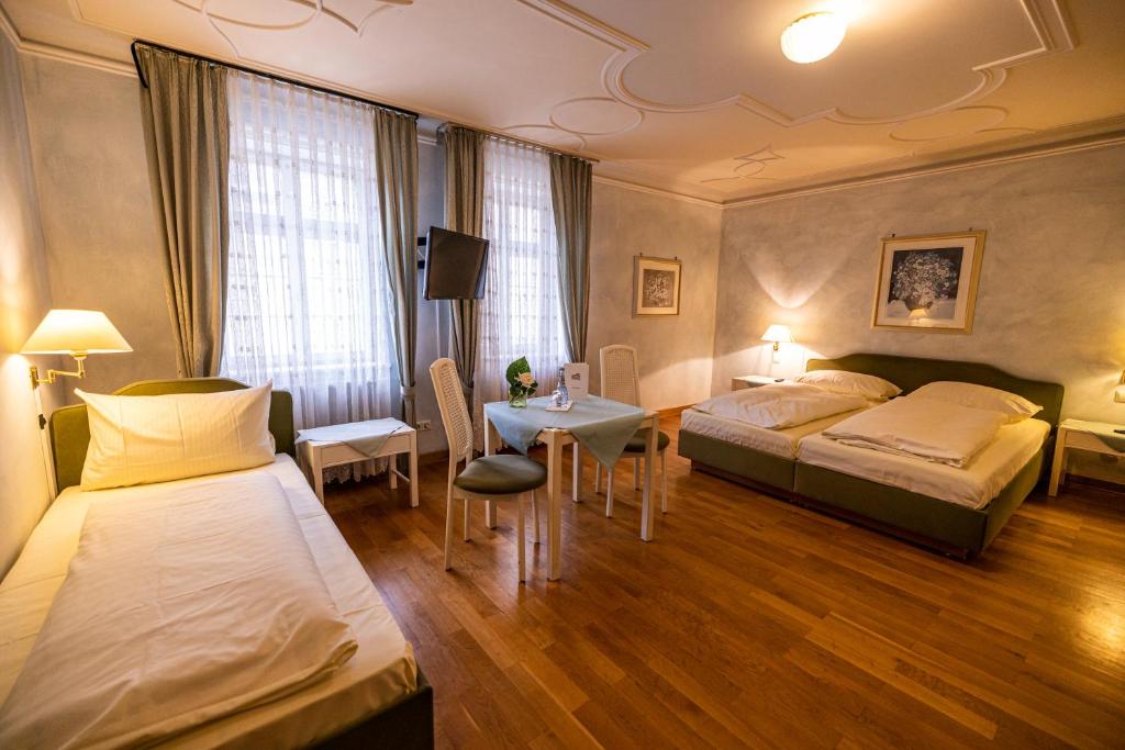 a hotel room with two beds and a table at Hotel & Restaurant Zum Riesen in Walldürn