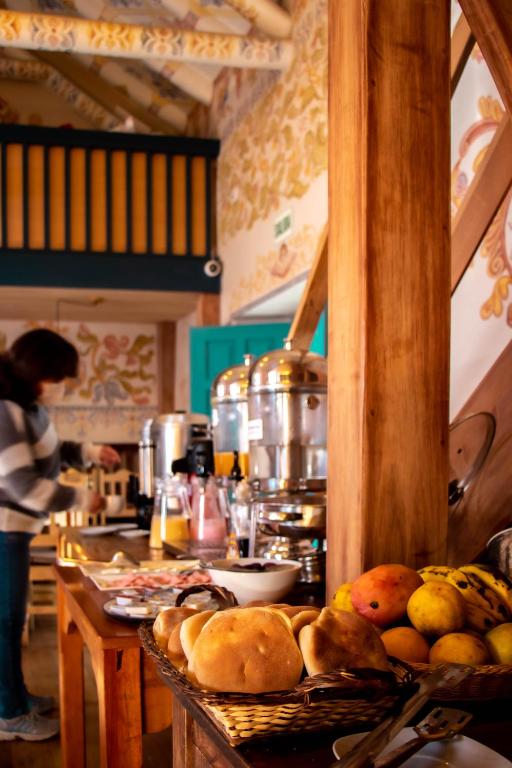una cucina con tavolo e cibo sopra di Nao Victoria Hostel a Cuzco