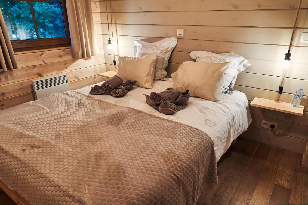 a bedroom with a large bed with two pillows at le nid des Mésanges in Bullange