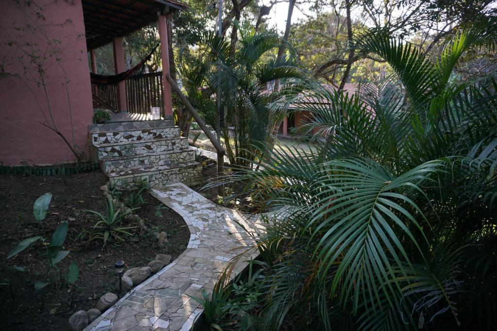 un giardino con passerella in pietra di fronte a una casa di Casa das Irmãs - Só Mulheres - Women Only a Vale do Capao