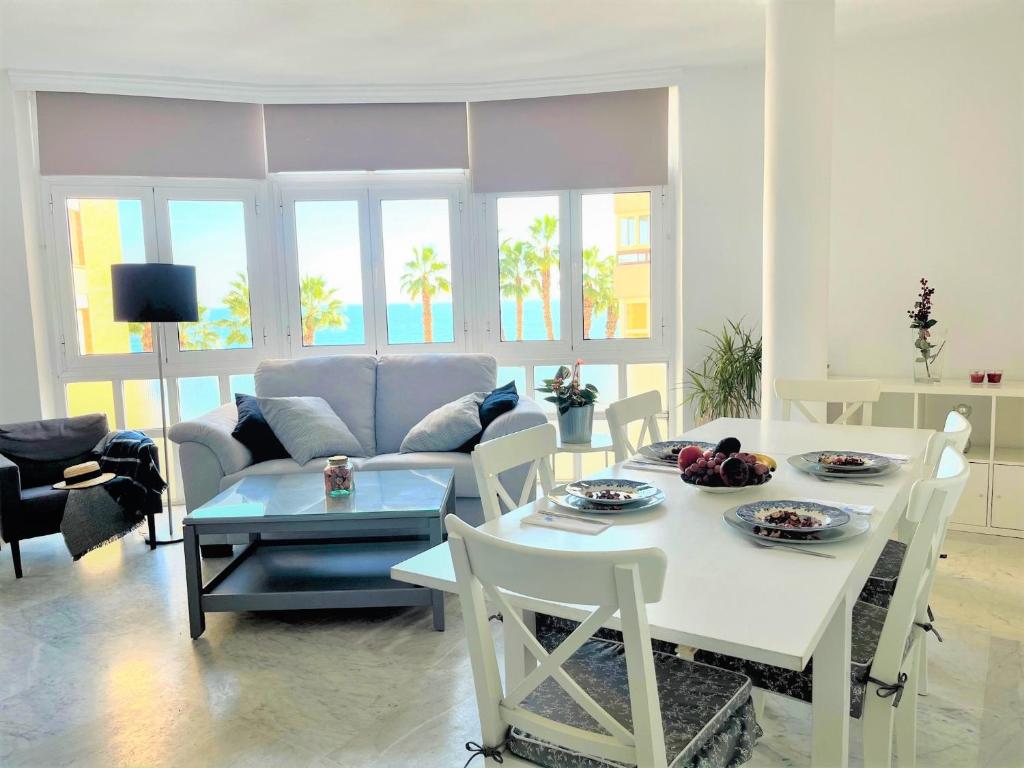 sala de estar con mesa y sofá en Frente a la playa Malagueta Arenal, 10 personas, en Málaga