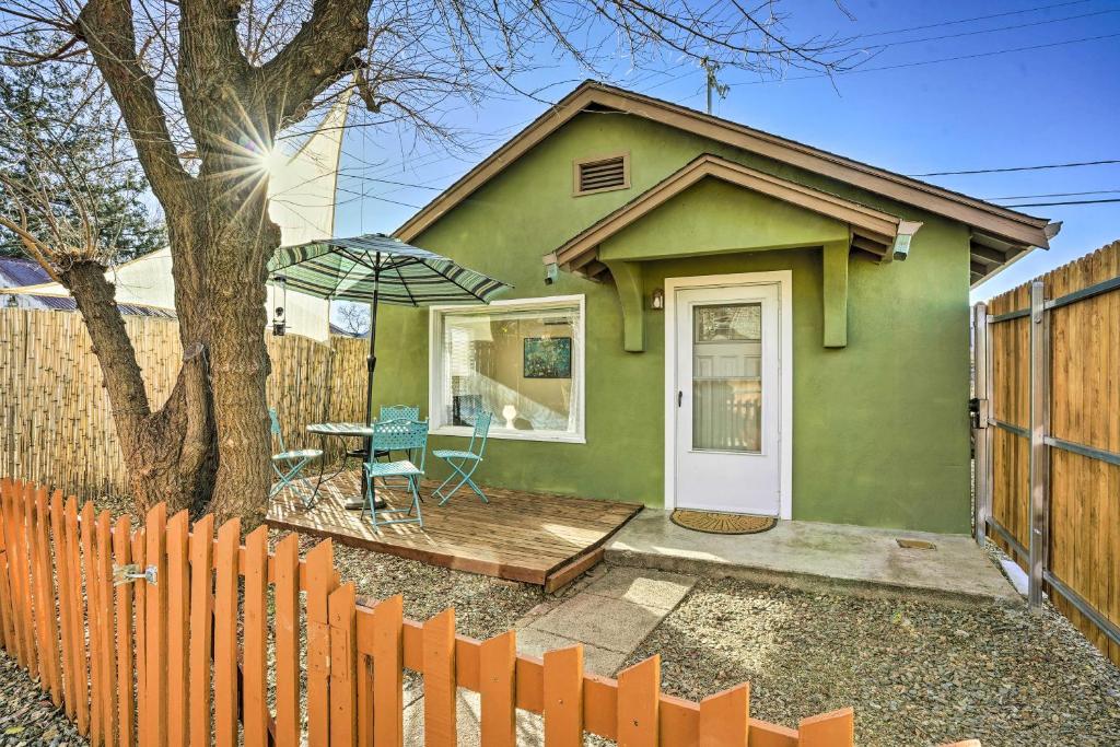 ein grünes Haus mit einem Tisch und einem Zaun in der Unterkunft Vibrant Prescott Cottage with Private Backyard! in Prescott