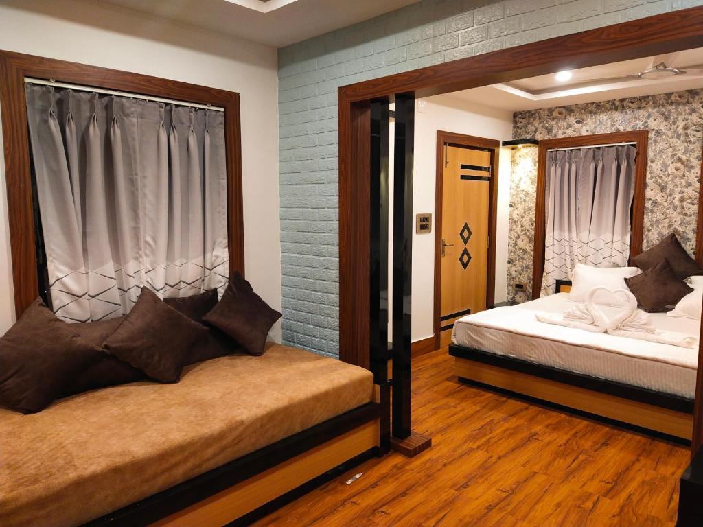 a bedroom with two beds and a window at CHARULATA RESIDENCY in Bolpur