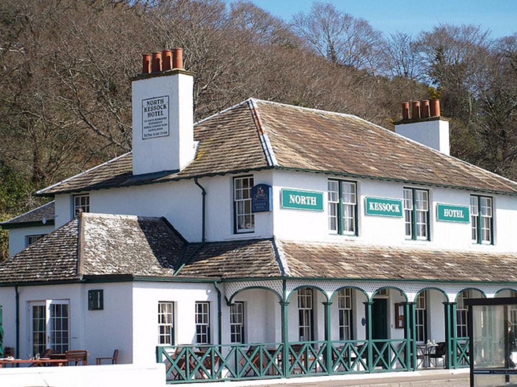 a white building with a clock on top of it at North Kessock Hotel in Inverness