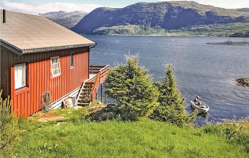 une maison au bord d'un lac avec un bateau dans l'établissement Stunning Home In Mly With Kitchen, à Måløy