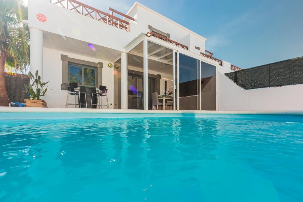 een villa met zwembad voor een huis bij VILLA RENATO in Playa Blanca