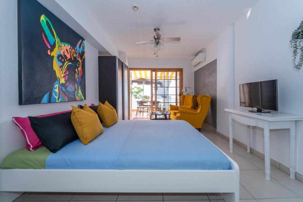 una camera da letto con un grande letto con cuscini colorati di 1013 studio Garden City a Playa Fañabe