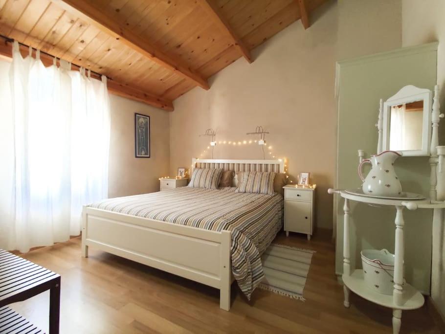 a bedroom with a large white bed and a window at Casa Rural Tozolosolobos in Otero de Bodas