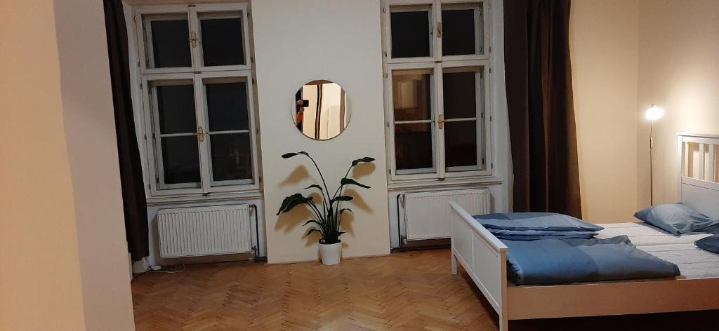een slaapkamer met een bed en 2 grote ramen bij Apartman Josef in Praag