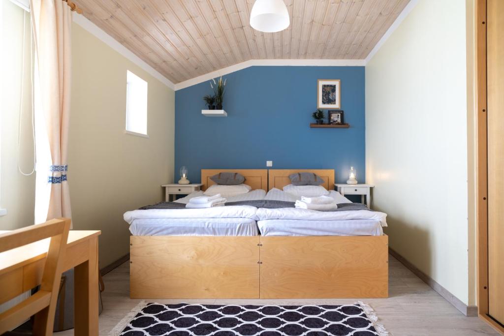 um quarto com uma cama com uma parede azul em Roograhu guesthouse&resto em Hiiessaare