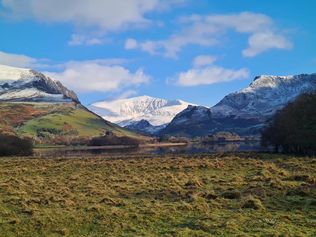 a view of snow covered mountains and a lake at North Wales Cosy Cottage with views near Eryri Snowdonia in Nantlle