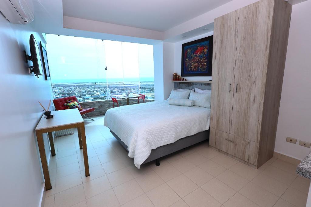 een slaapkamer met een bed en een groot raam bij Mejor que un Hotel in Salinas