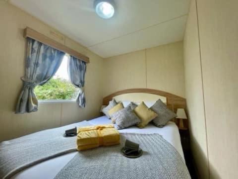 a bedroom with a large bed with a window at Park Dean Morcambe in Bare