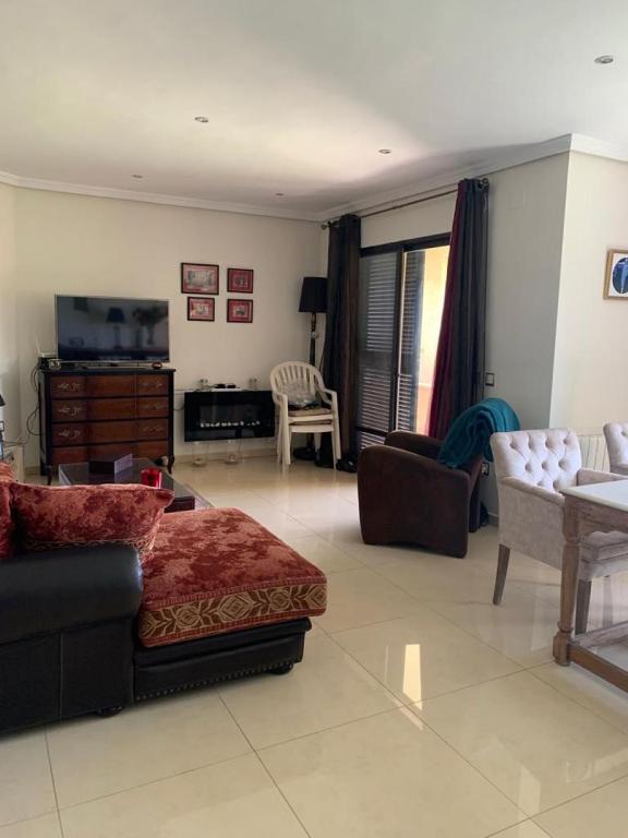 a living room with a couch and a tv at Camino del Faro LALBIR Alicante in Albir
