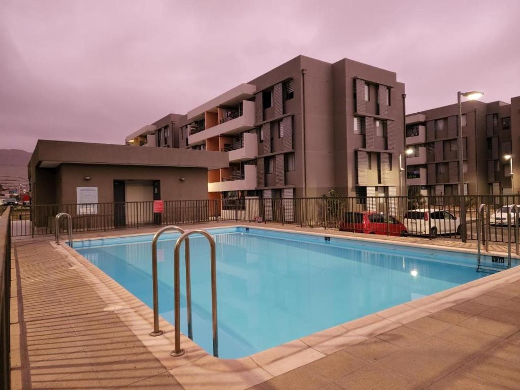 a large swimming pool in front of a building at Departamento por día 3 dormitorios y 2 baños in Arica