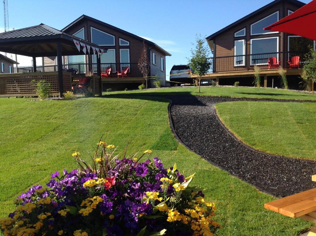 a house with a garden with flowers in the yard at Stardust Inn and Chalets in Pincher Creek