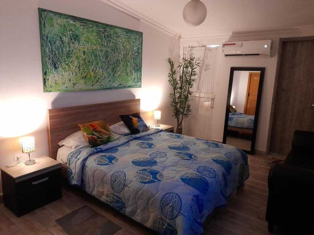 ein Schlafzimmer mit einem Bett und einem Gemälde an der Wand in der Unterkunft APTO 11 CALI - sur in Cali