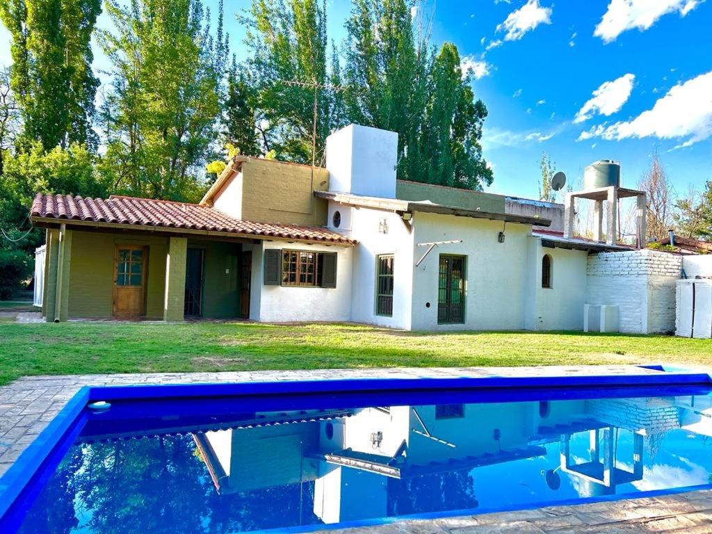 una casa y una piscina frente a una casa en Hermosa y amplia casa en la mejor ubicacion de Chacras, con piscina y jardin en Luján de Cuyo