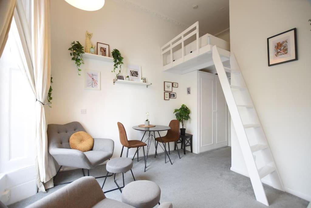 a living room with a staircase and a table and chairs at Fabulous Studio Apartment Camden in London