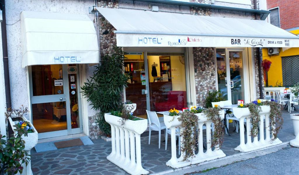 een restaurant met tafels en stoelen voor een gebouw bij Albergo Marsari in Peschiera del Garda
