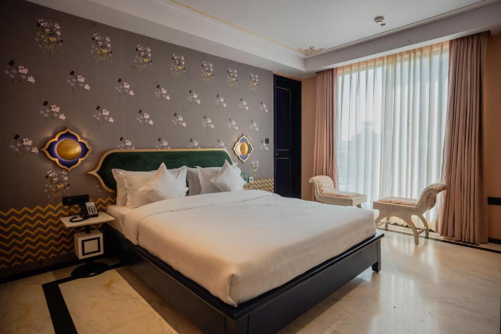 Bur'Dera - a Boutique Luxury Hotel في جايبور: غرفة نوم بسرير كبير ونافذة كبيرة