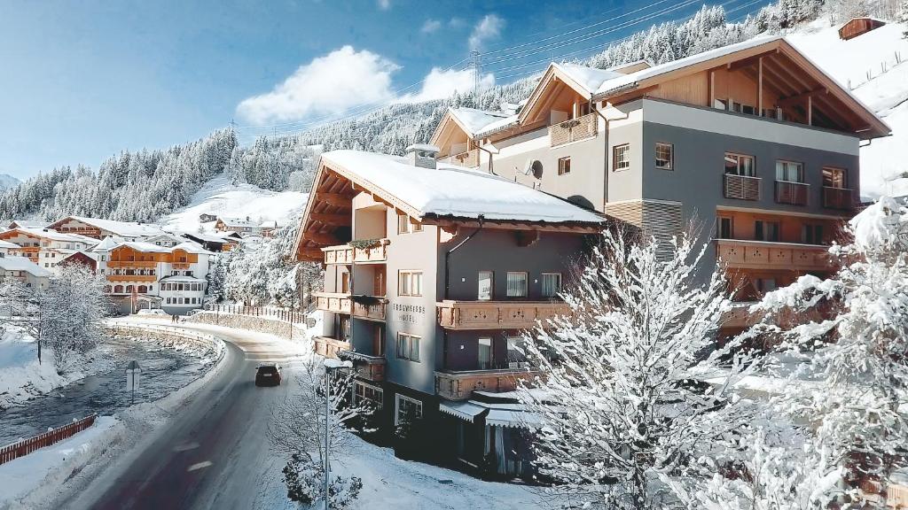 a building in the snow with a road in front at Hotel Edelweiss in Gerlos