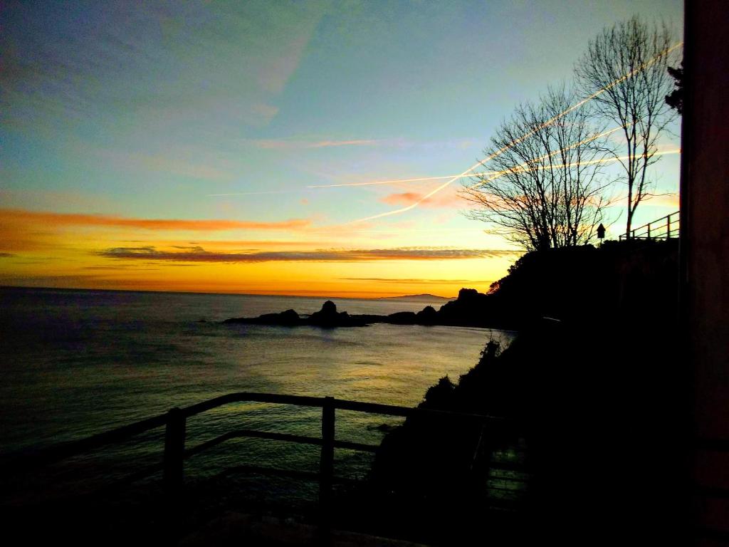 una puesta de sol sobre un cuerpo de agua con el océano en Arrigorri Ostatu Jatetxea, en Ondárroa