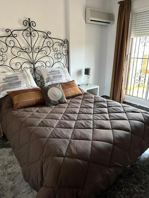 a bedroom with a large bed with a brown comforter at Casa Emilio in Pulianas