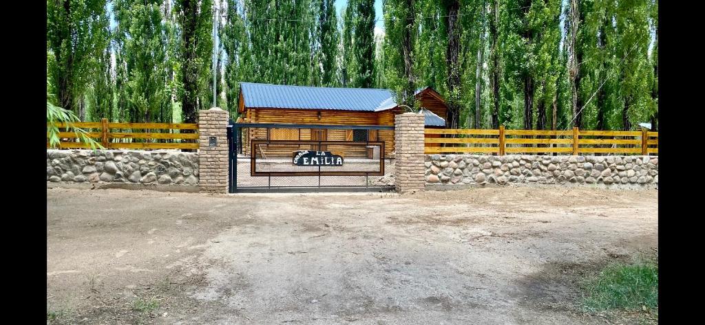 a wooden building with a gate in front of a fence at Cabaña LA EMILIA Private house in Uspallata