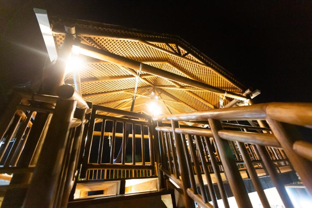 una barandilla de madera con una luz encendida por la noche en Hotel Villas Lucciana en El Paredón Buena Vista