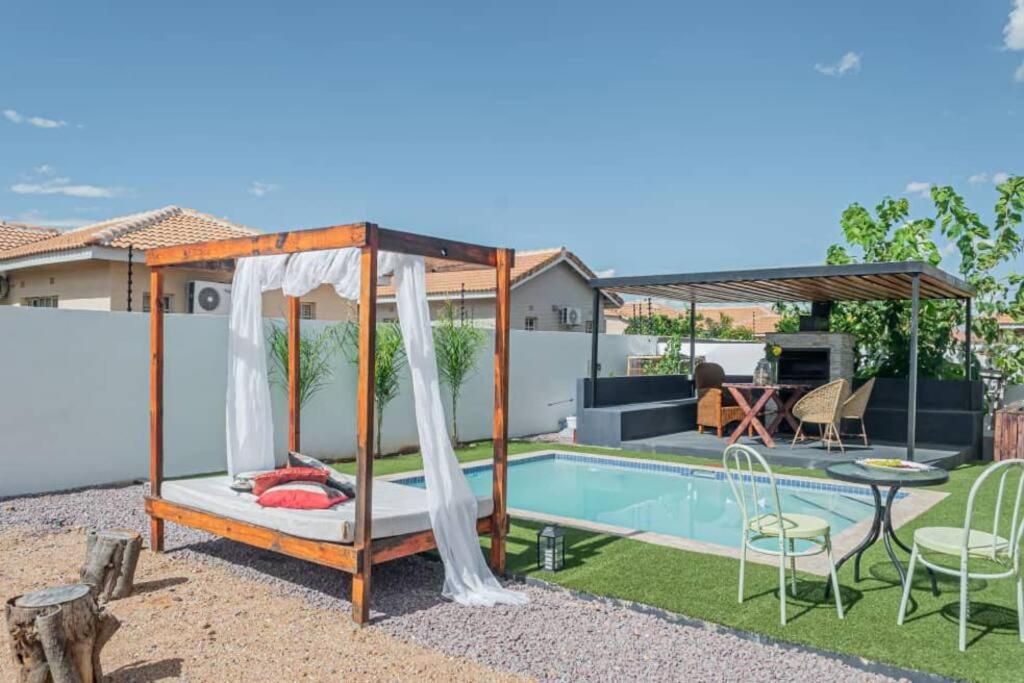 a backyard with a swing and a swimming pool at Ellen Topo in Gaborone
