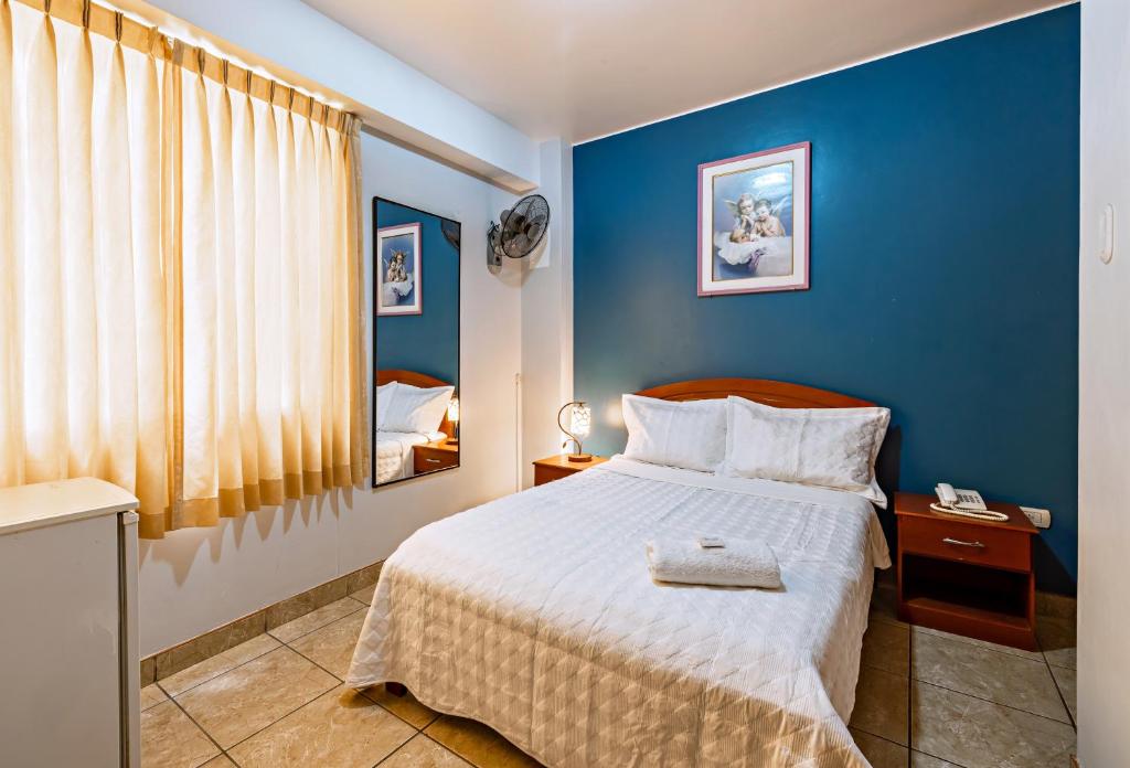 a bedroom with a bed with a blue wall at Hotel Costa Norte in Chiclayo