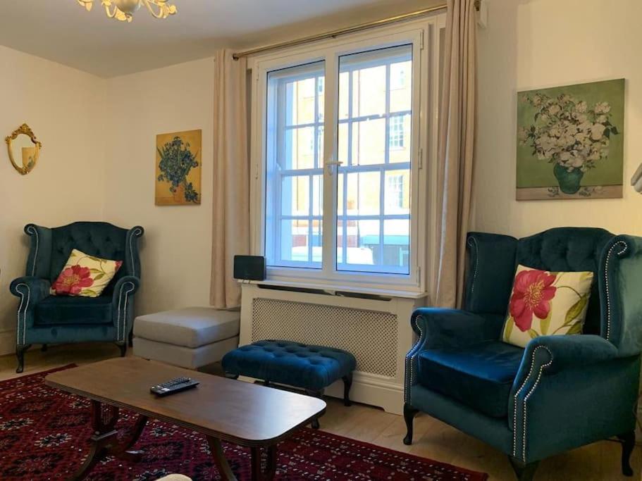 un soggiorno con due sedie, un tavolo e una finestra di A stunning 3 bedroom house a Londra