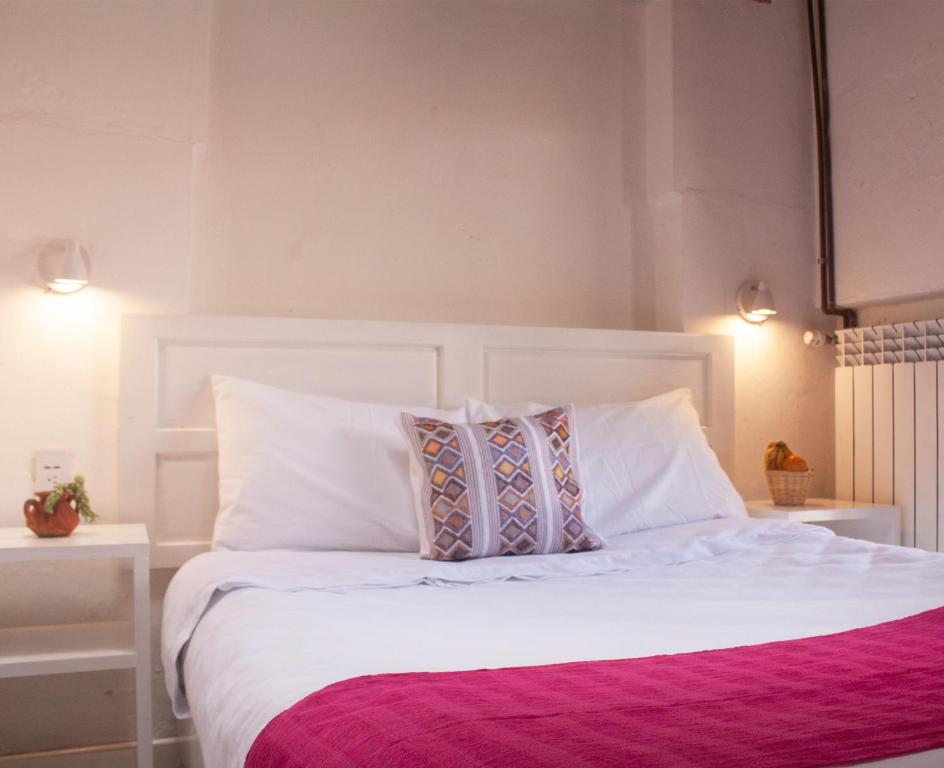 um quarto com uma cama branca e 2 almofadas em Noma Bed & Breakfast em San Cristóbal de Las Casas
