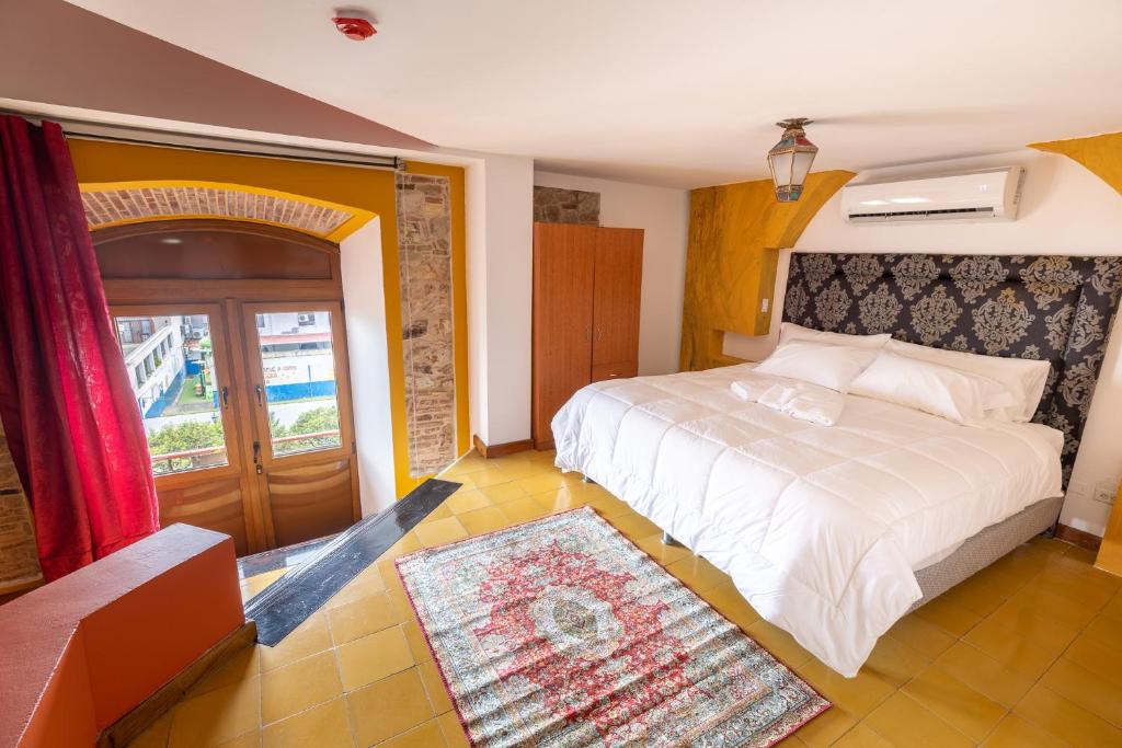 a bedroom with a large white bed and a window at Oasis Hotel in Panama City