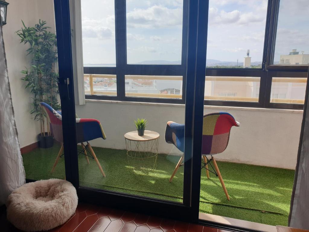 a room with a window with chairs and a table at Aiyra Beach House in Costa da Caparica