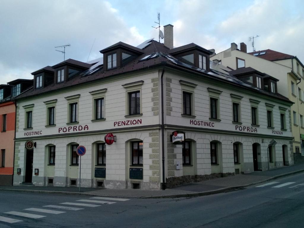 ein weißes Gebäude an der Straßenseite in der Unterkunft Penzion Poprda in Klatovy