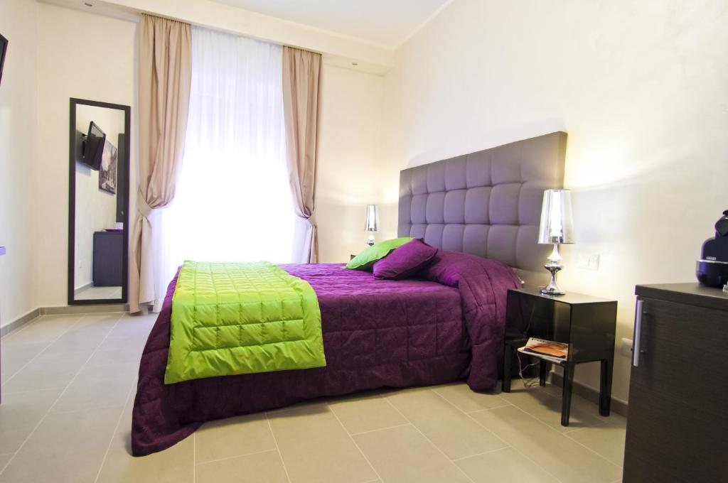 a bedroom with a purple bed with a green blanket at Domus Fontis in Rome