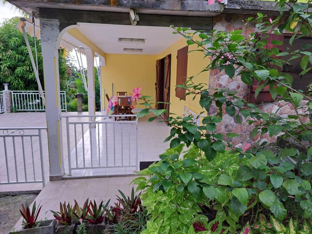 un porche de una casa con una valla y flores en Hébergement Les HIBISCUS, en Trois-Rivières