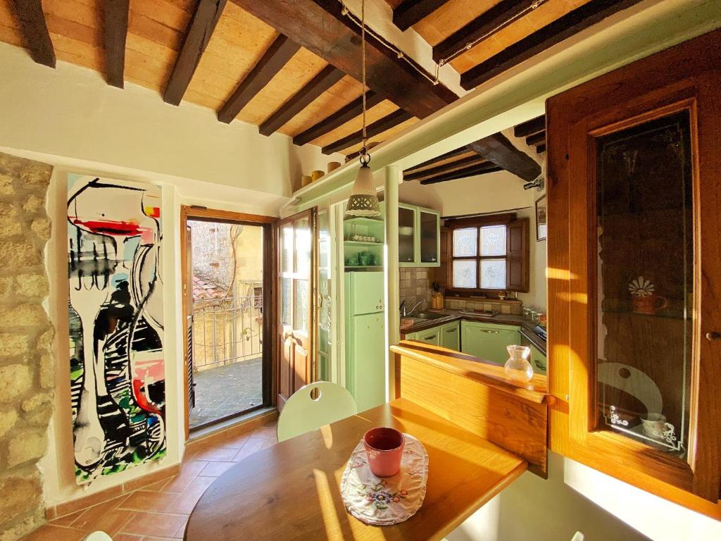 eine Küche mit einem Tisch und einem großen Fenster in der Unterkunft Casa Armandina - Tuscan ToBe in Santa Fiora