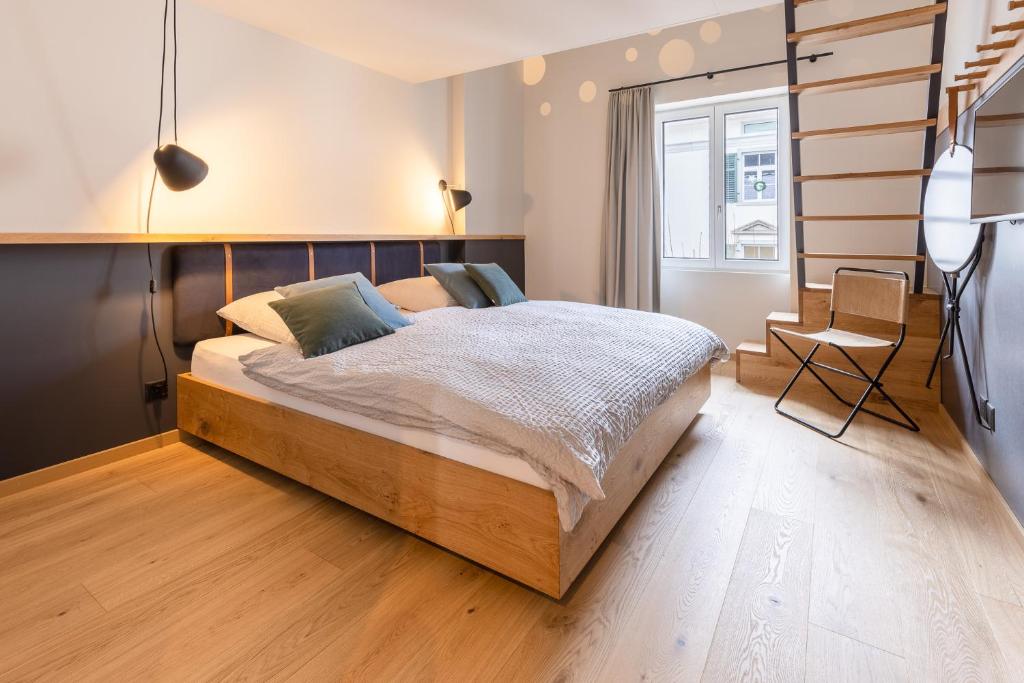 1 dormitorio con 1 cama grande y 1 silla en Gyger Restaurant Confiserie B&B, en Thusis