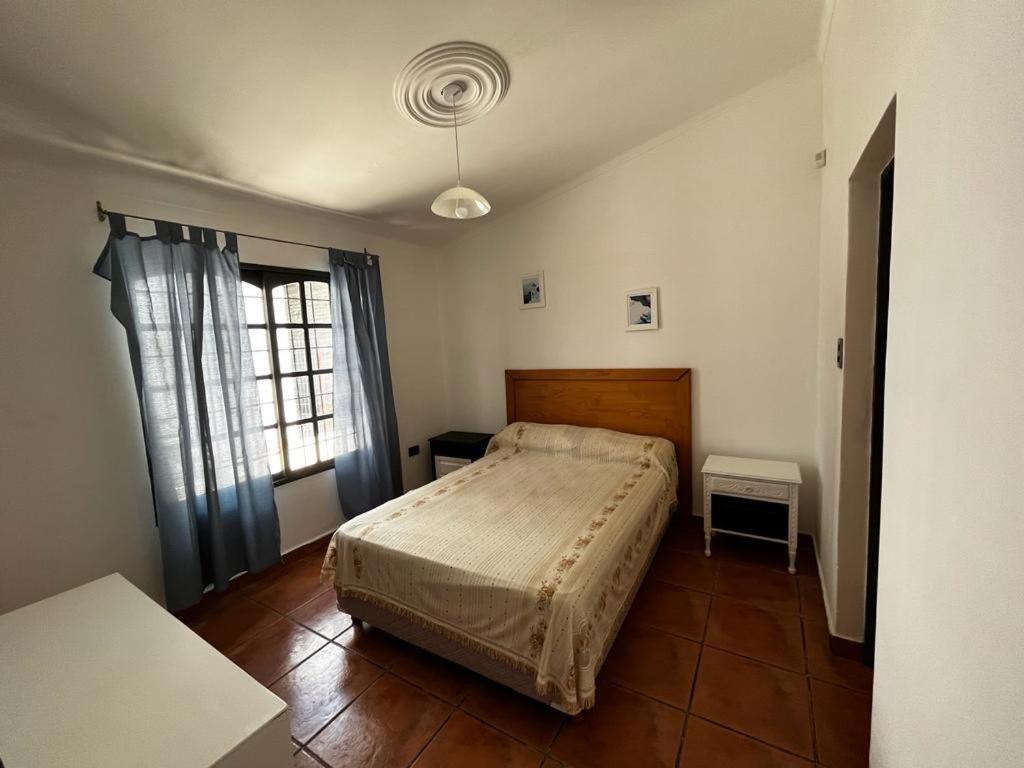 1 dormitorio con cama y ventana en casa tropero sosa en Maipú