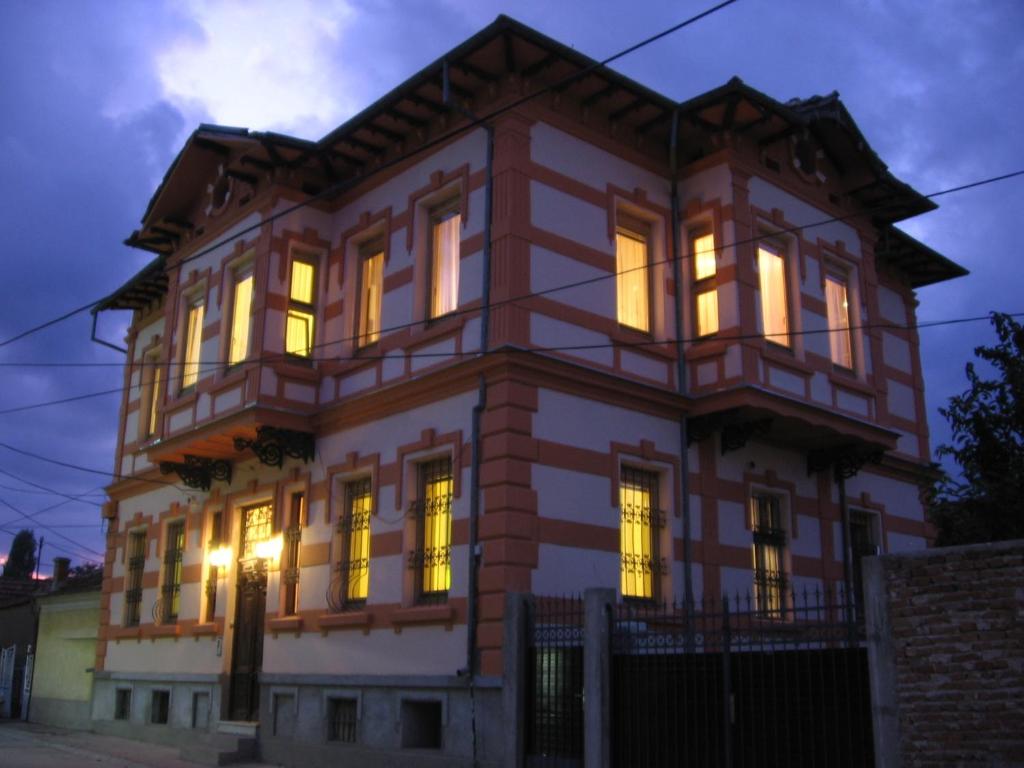 una casa grande con sus luces encendidas por la noche en Chola Guest House, en Bitola